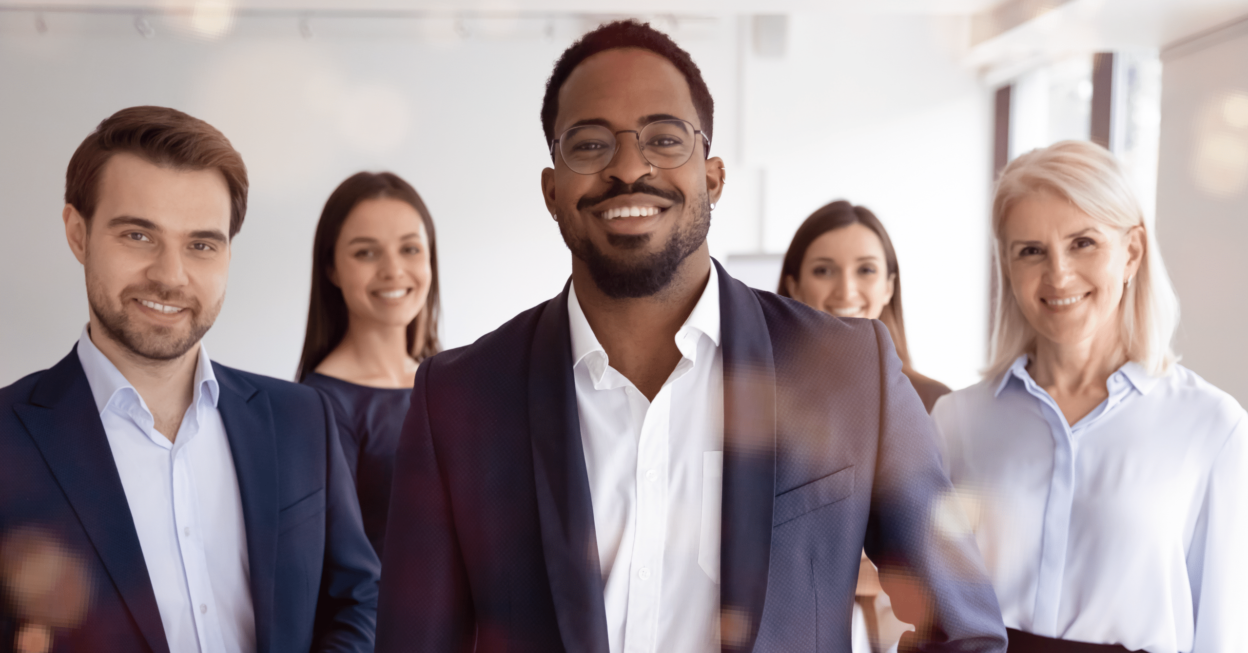 A group of smiling diverse people representing diversity strategy in organizations.