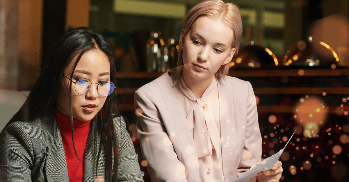 Two young female professionals looking at a screen are discovering ways to optimize their talent strategy with new VMS technology.