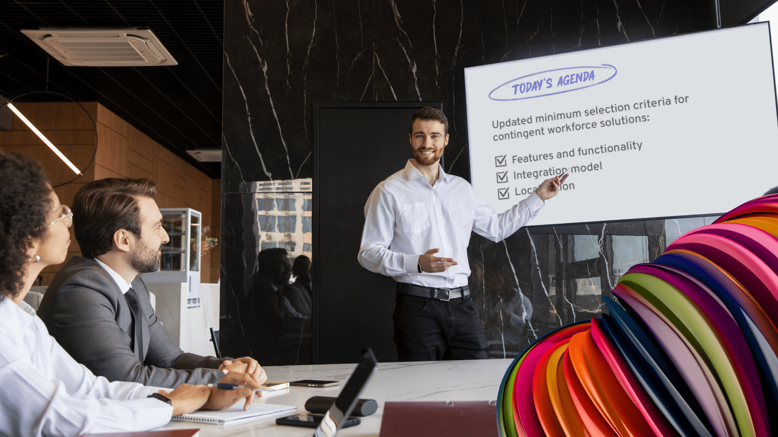 A group presentation with the presenter pointing to a whiteboard.