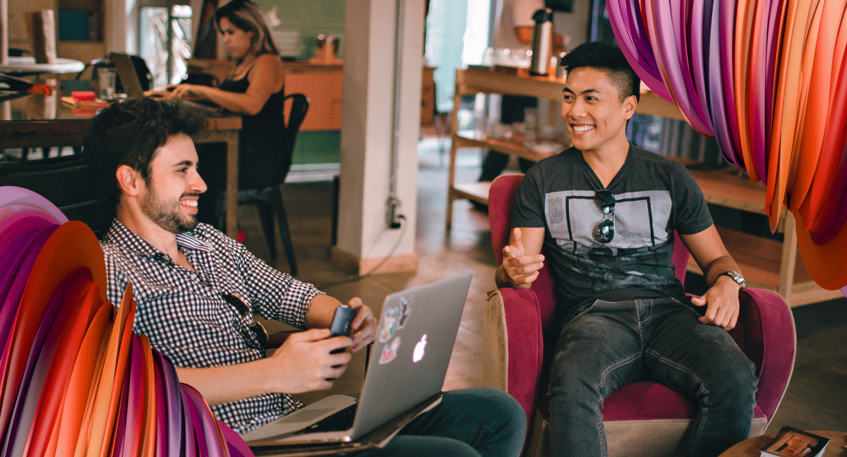 Two contingent workers bond over task in an open office space.