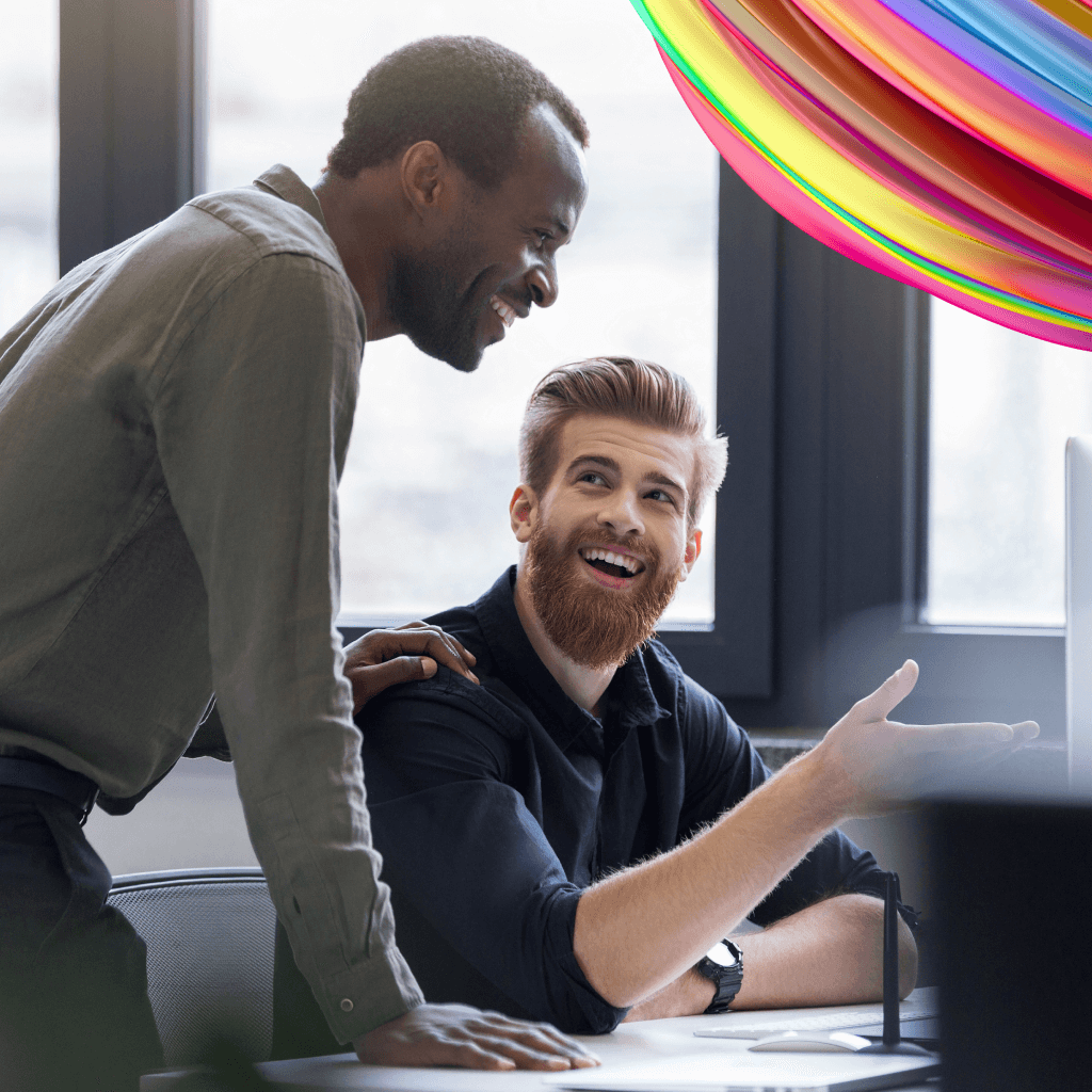 Two statement of work contingent employees are working on a project together and smiling.