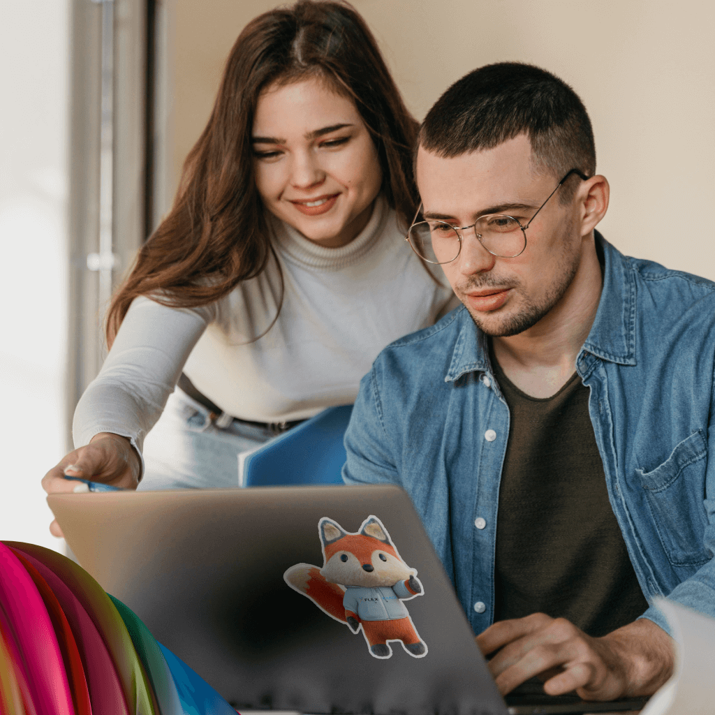 Two temporary workers sourced directly are collaborating and viewing a project on a laptop.