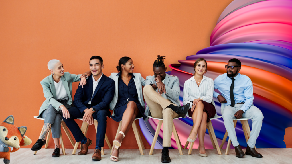 A group of extended workforce employees sits in white chairs against an orange wall looking happy.