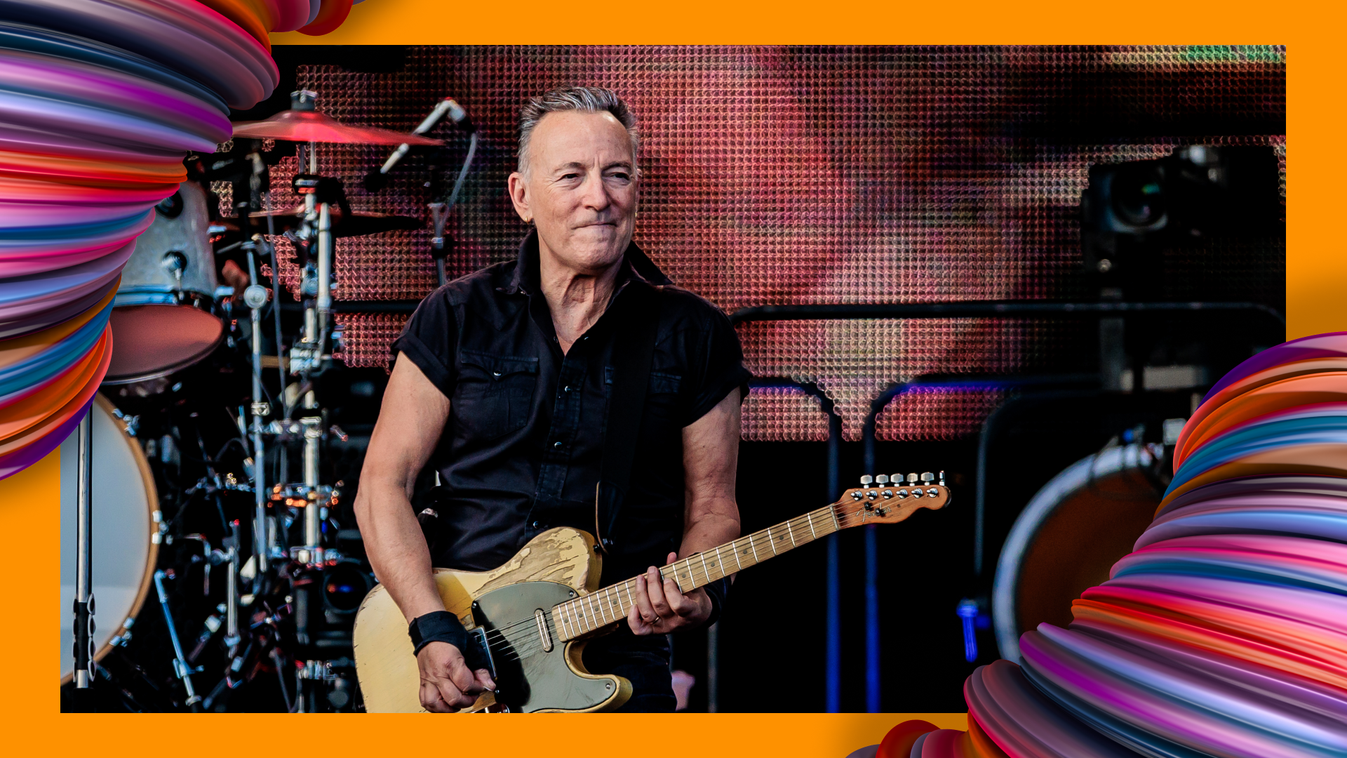 Bruce Springsteen holding a guitar with Flextrack conduits on the sides.