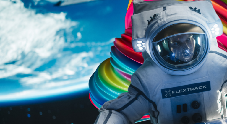 A Flextrack branded astronaut is looking at a solar panel, suggesting gathering workforce data for a VMS